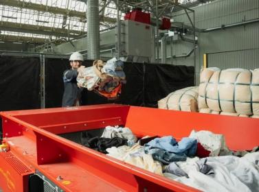 A Carbios employee loads textile onto the preparation line