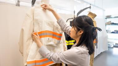 Huieun Do, M.A. ’25, a member of the Performance Apparel Design Lab, works with a prototype of the redesigned fire gear the lab is developing in coordination with professional firefighters.