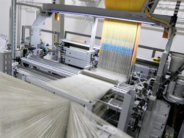 The Fraunhofer WKI double-rapier weaving machine with the Jacquard attachment in the upper of the photo.  