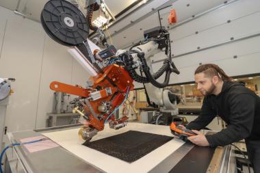 Robotergestütztes Tapelegen im Technikum des TITK Rudolstadt. Maschinenführer Sandro Eippert in Aktion.