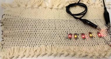 Supercapacitor yarns integrated into a fabric for powering LEDs.