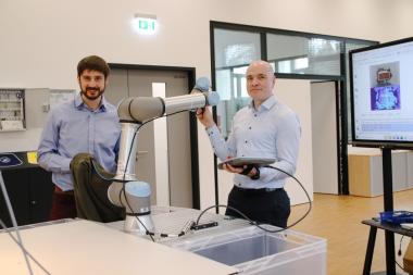 Prof. Dr.-Ing. Jens Schäfer (links) und Prof. Dr.-Ing. Steffen Greiser wollen smarte Textilien regional recyceln. Dafür setzen sie sowohl am Produktdesign als auch an der Sortierung durch Robotik und KI an.